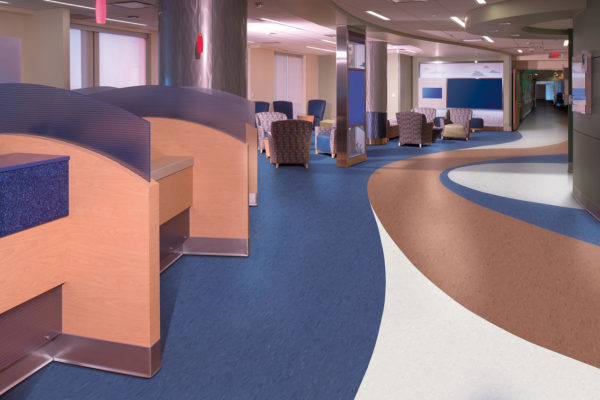 A windy, colorful view of a modern hospital nurses station in a high rise medical center.